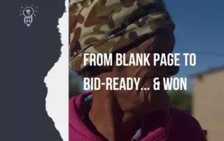 Elderly woman in a camouflage hat and pink fleece standing outdoors in a rural Northern Cape community under a clear blue sky
